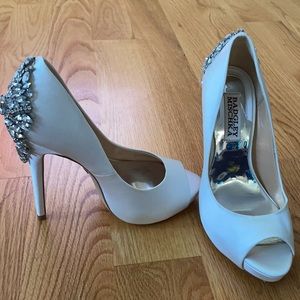 Badgley Mischka Kiara peep-toe white wedding pumps with embellishments.